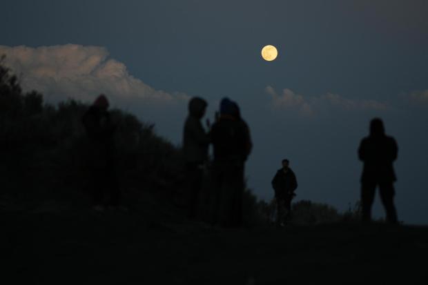 Des étudiants observent la lune près du campement sur les pentes du Popocatépetl.