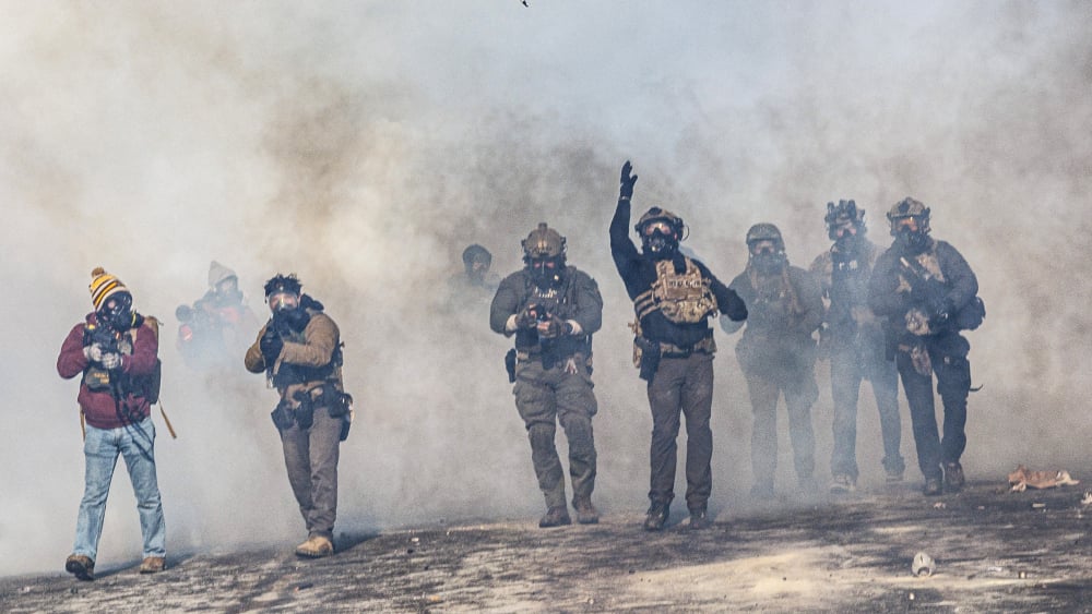 Agent fédéral lançant un gaz lacrymogène lors d'une intervention