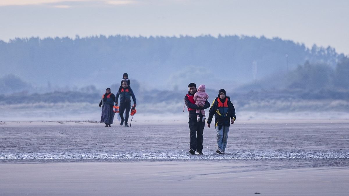 Groupe de policiers et migrants près de la Manche